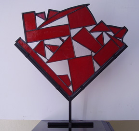 Stained glass abstract design in red with metal stand