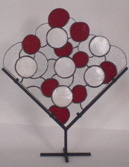 stained glass abstract with red glass and shells on stand